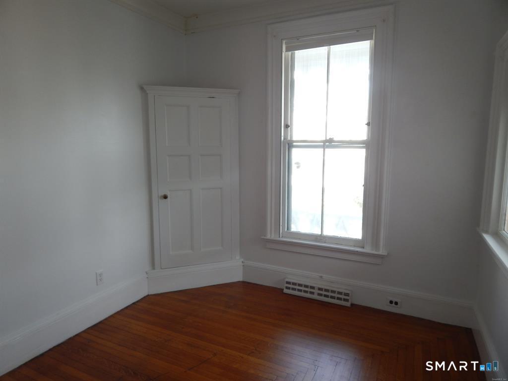 5 Clover Street Ansonia, CT 06401 - Photo 4 of 10 an empty room with wooden floor and windows