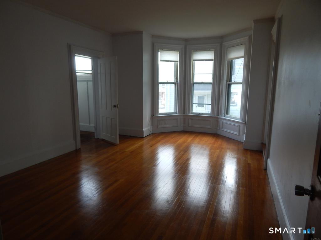 5 Clover Street Ansonia, CT 06401 - Photo 8 of 10 an empty room with wooden floor and windows