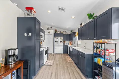 a open kitchen with cabinets a sink and wooden floor
