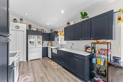 a kitchen with granite countertop a refrigerator and a stove top oven