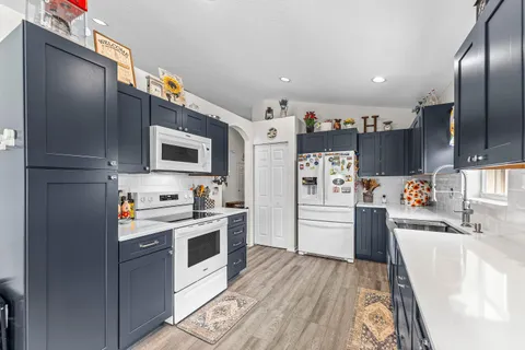 a kitchen with stainless steel appliances granite countertop a refrigerator a stove top oven a sink and dishwasher