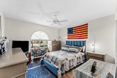 a spacious bedroom with a bed a table and a large window