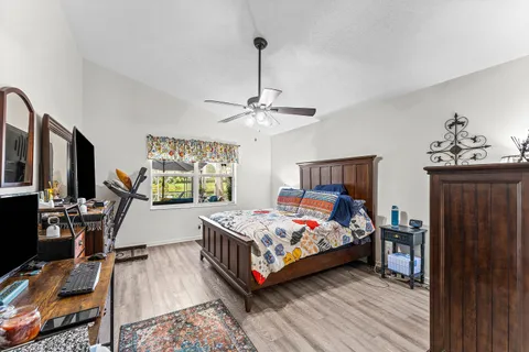 a bedroom with a bed and wooden floor