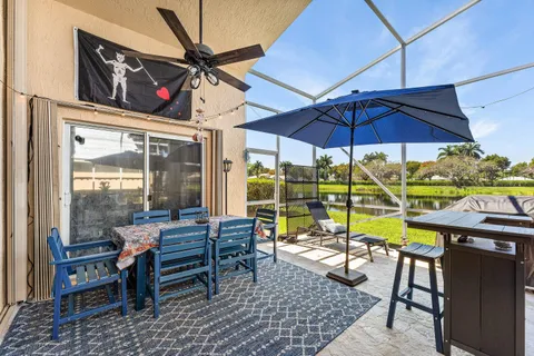 a view of a patio with a table and chairs under an umbrella