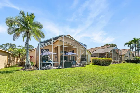 a view of a house with a big yard and large trees