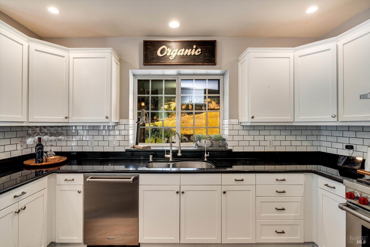 2980 Warm Springs Road Glen Ellen, CA 95442 - Photo 26 of 59 a kitchen with granite countertop white cabinets and black appliances
