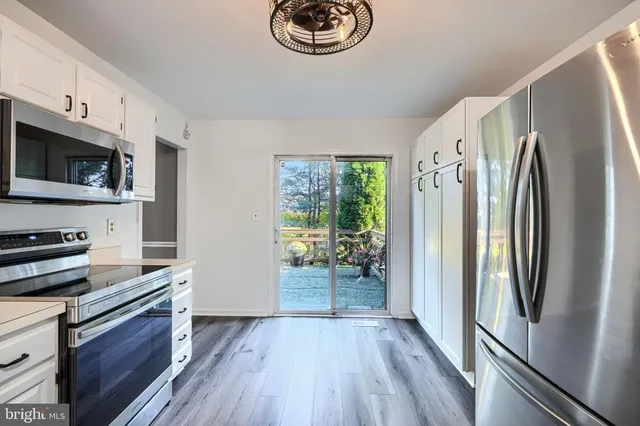 a kitchen with stainless steel appliances a refrigerator microwave and stove top oven