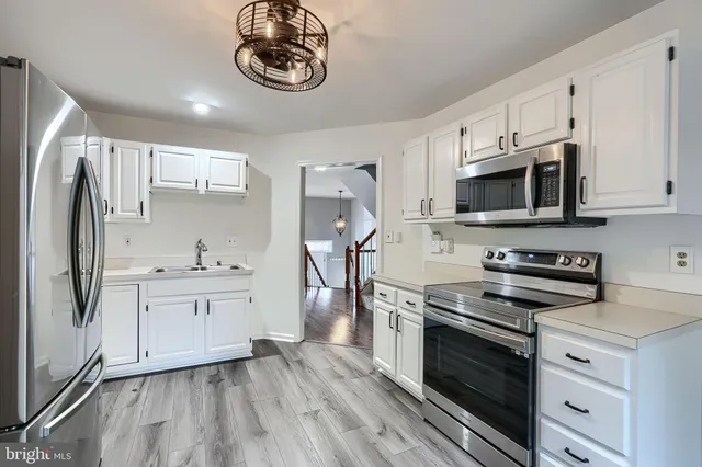 a kitchen with stainless steel appliances a stove microwave and sink