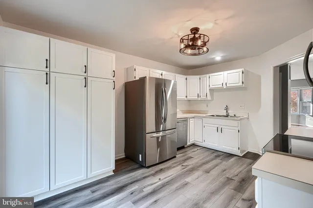 a kitchen with granite countertop stainless steel appliances a refrigerator cabinets and a sink