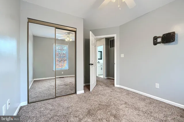 an empty room with closet and windows