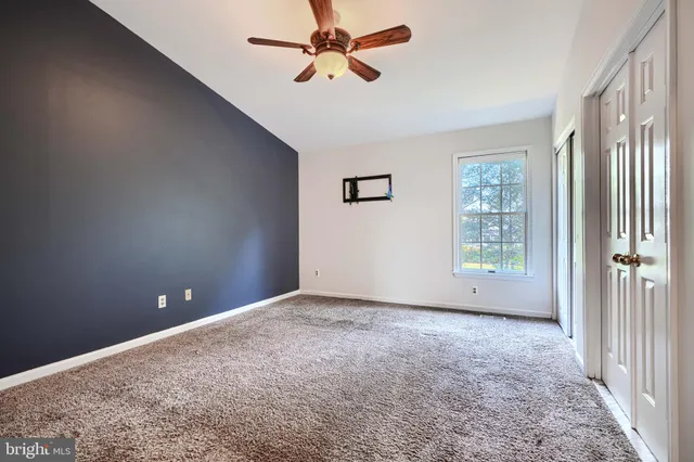 a view of empty room with ceiling fan
