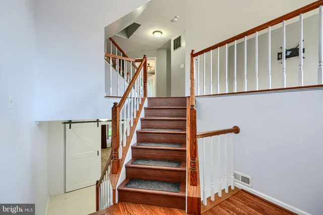 a view of staircase with lots of frames on wall and a window