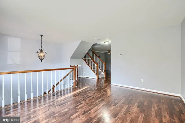 a view of a hallway with wooden floor and stairs