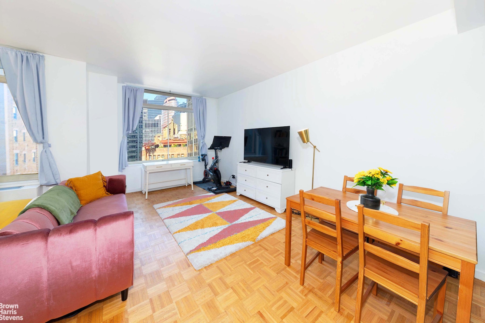 145 East 48th Street, Unit 15A Manhattan, NY 10017 - Photo 1 of 5 a living room with furniture and a flat screen tv