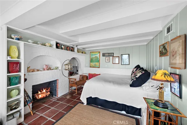 a bedroom with a bed a fireplace and a window