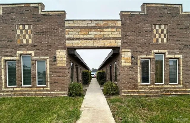 front view of a brick house with a yard