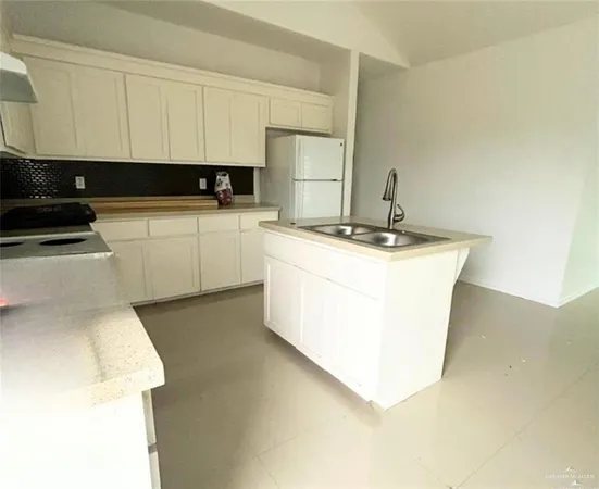 a kitchen with a sink a stove and cabinets