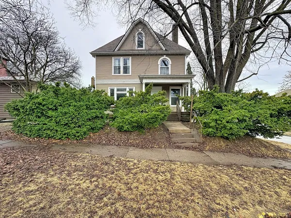 a front view of a house with a yard and trees