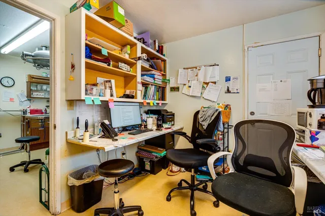 a work room with furniture a flat screen tv and a floor to ceiling window