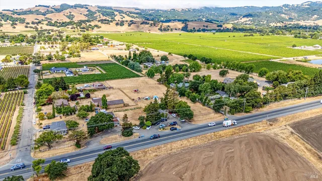 an aerial view of ocean and residential houses with outdoor space