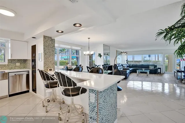 a view of a dining room and livingroom with furniture wooden floor a chandelier