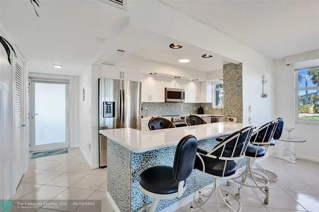 a kitchen with a refrigerator a sink and a stove top oven