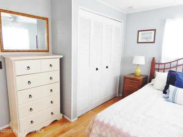 a bedroom with a bed and a mirror on the dresser