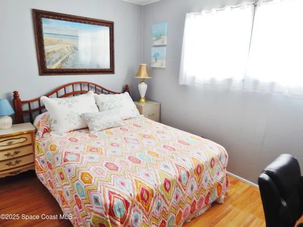 a bedroom with a bed and a painting on the wall