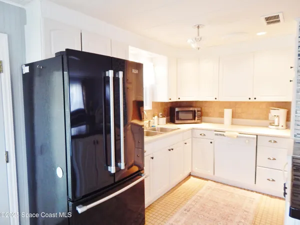 a kitchen with granite countertop a refrigerator and a sink