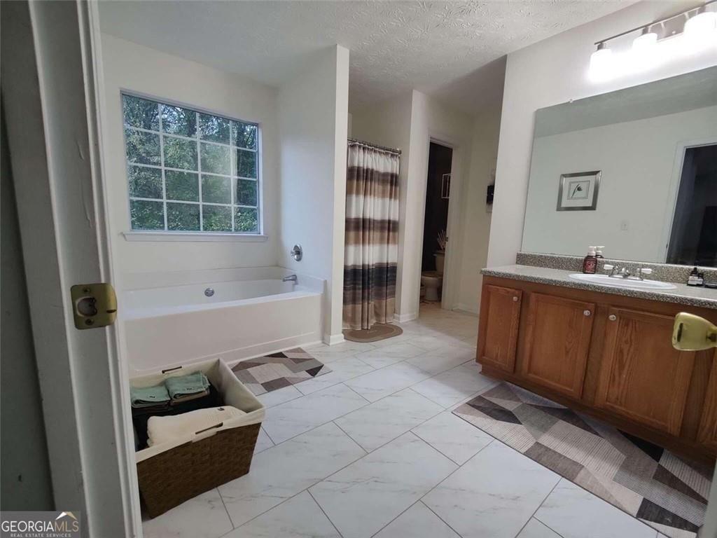 1600 Keystone Drive Conley, GA 30288 - Photo 7 of 12 a bathroom with a tub sink and a mirror