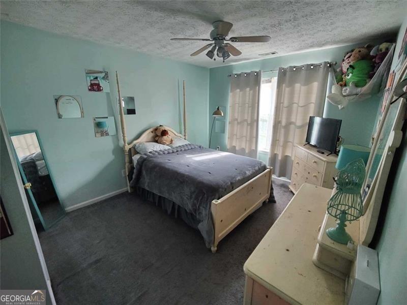 1600 Keystone Drive Conley, GA 30288 - Photo 9 of 12 a spacious bedroom with a bed and a chandelier