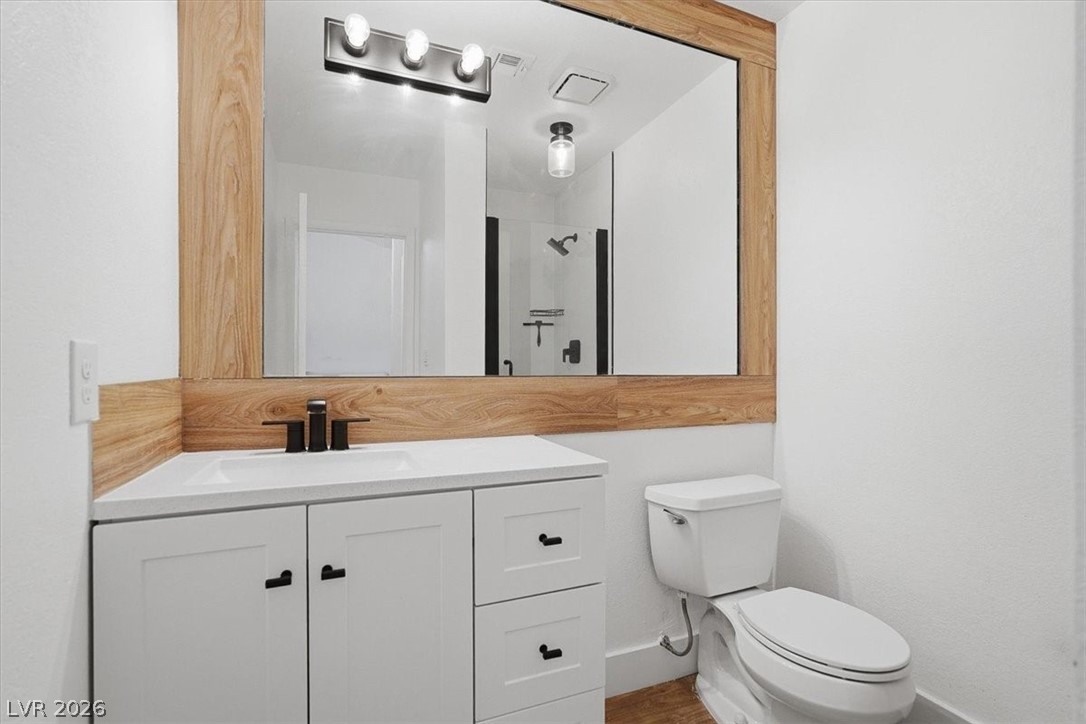 6250 West Flamingo Road, Unit 93 Las Vegas, NV 89103 - Photo 29 of 38 This bathroom features a contemporary vanity and mirror, complemented by a sleek toilet.