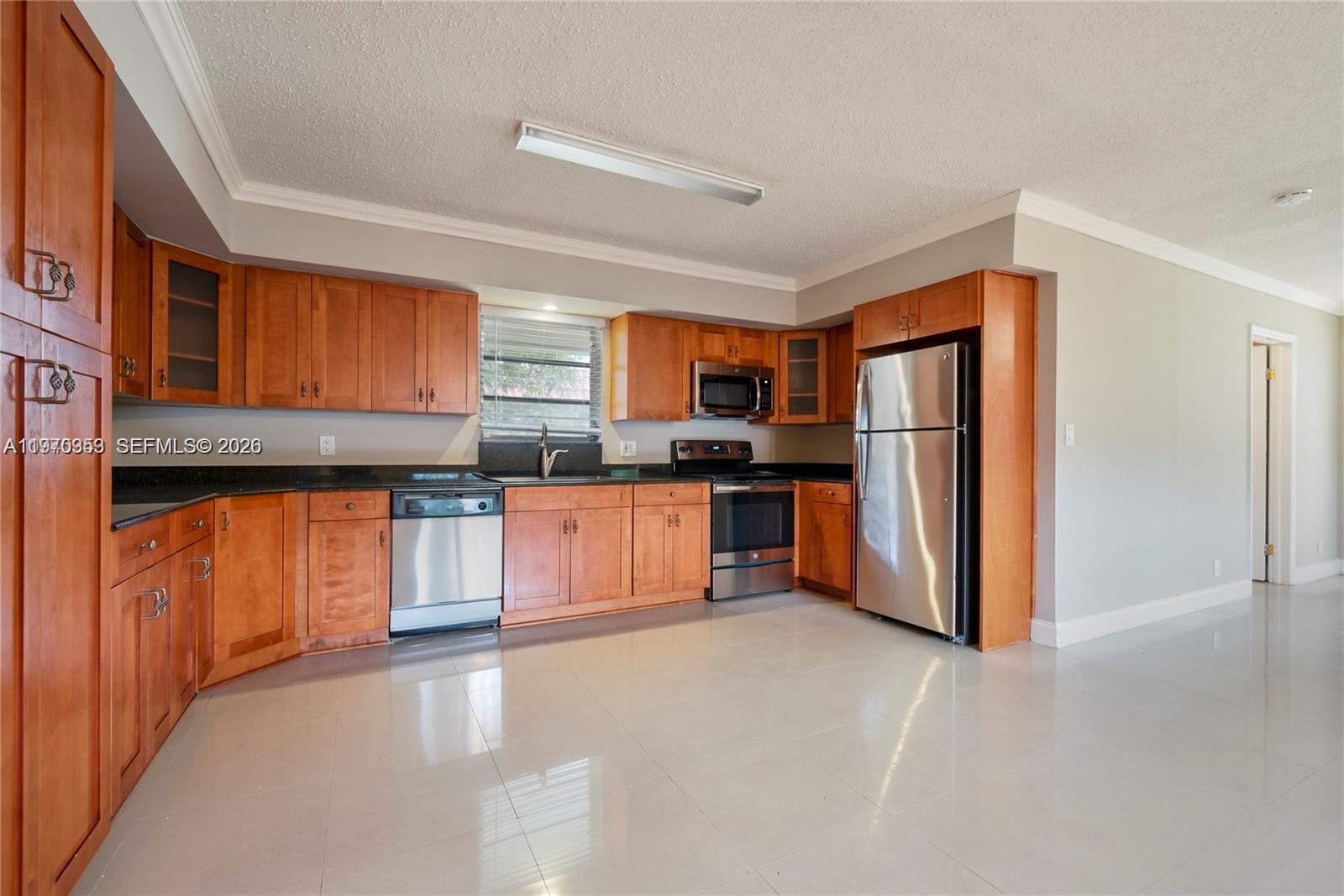 a kitchen with stainless steel appliances granite countertop a refrigerator and a stove top oven