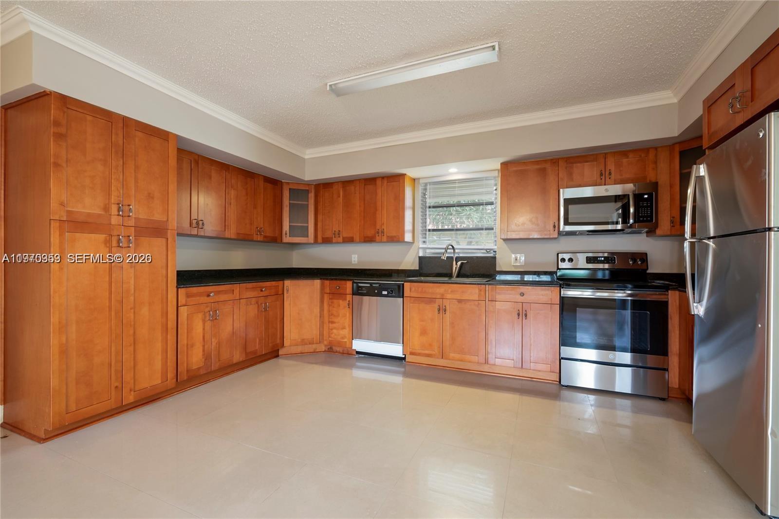 5632 Hayes Street Hollywood, FL 33021 - Photo 2 of 42 a kitchen with stainless steel appliances a refrigerator and a stove top oven