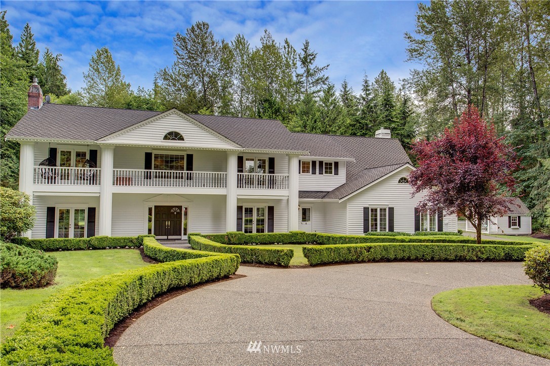 22128 Northeast 141st Place Woodinville, WA 98077 - Photo 1 of 1 a front view of a house with a garden and trees