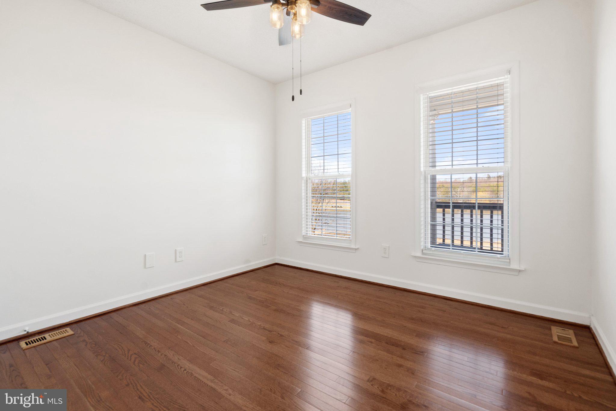 18464 Snaffle Lane Culpeper, VA 22701 - Photo 42 of 64 an empty room with wooden floor chandelier fan and windows