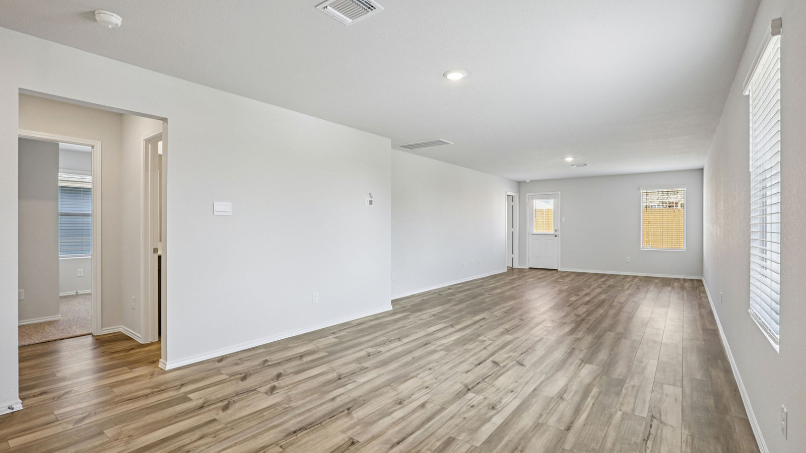 156 Wyatt Way Jarrell, TX 76537 - Photo 9 of 30 Spacious living area featuring wood-finish flooring, recessed lighting, and multiple windows with blinds