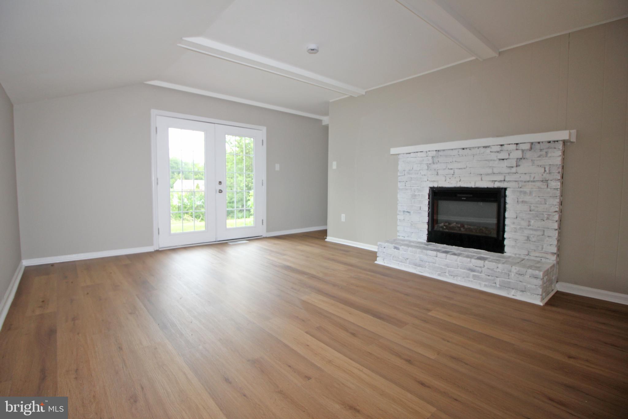 27 West Kennedy Drive Clementon, NJ 08021 - Photo 17 of 39 an empty room with wooden floor fireplace and windows