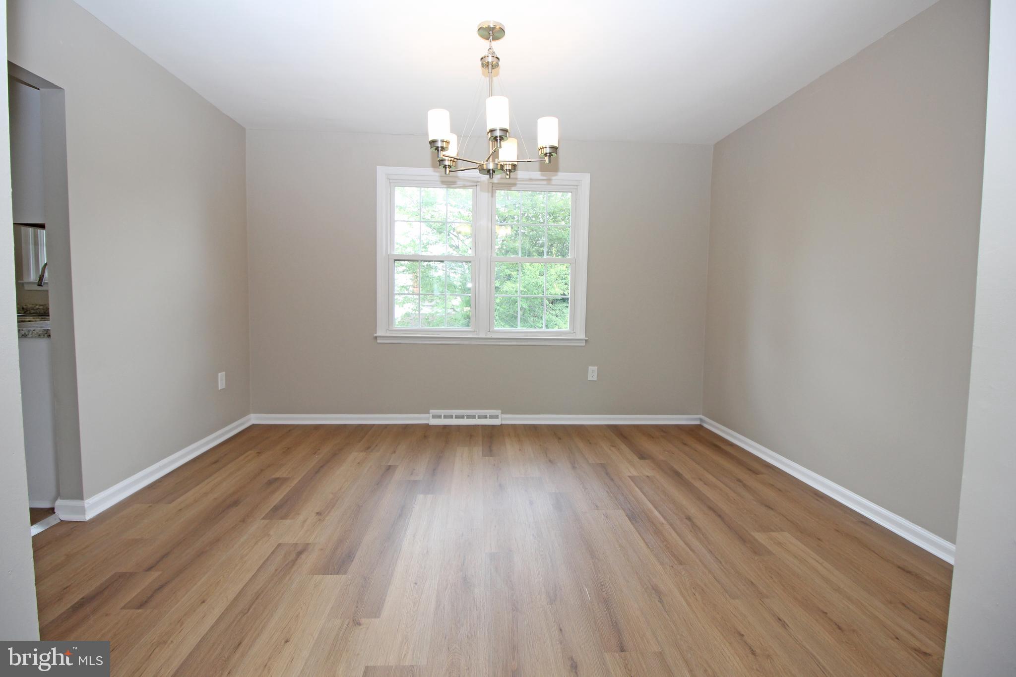 27 West Kennedy Drive Clementon, NJ 08021 - Photo 9 of 39 an empty room with wooden floor chandelier and window