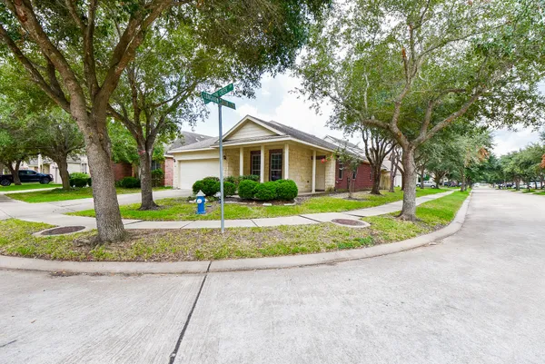 a front view of a house with a yard and trees