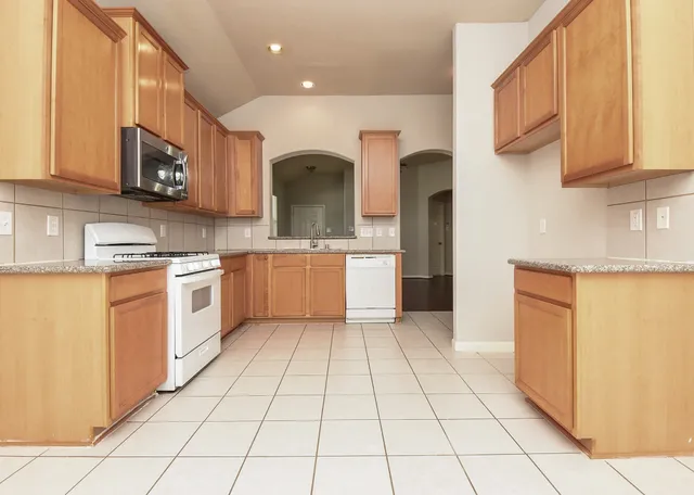 a kitchen with stainless steel appliances granite countertop a stove a sink and a refrigerator