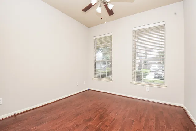 an empty room with a window and a ceiling fan