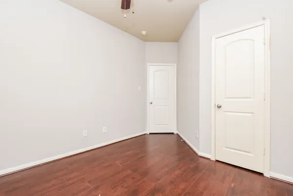 an empty room with fan and windows