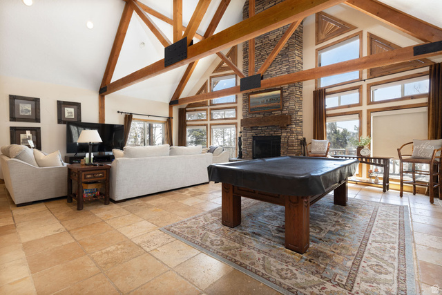 382 Ridgeview Street, Unit 8 & 9 Brian Head, UT 84719 - Photo 31 of 52 Vaulted ceilings with exposed wood beams, stone-faced fireplace with wood mantel, large windows with natural wood trim, and tile flooring