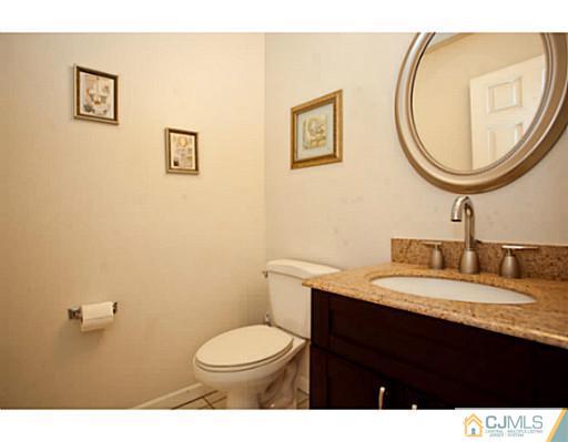 6 Valarie Road Edison, NJ 08820 - Photo 8 of 23 a bathroom with a granite countertop toilet a sink and a mirror