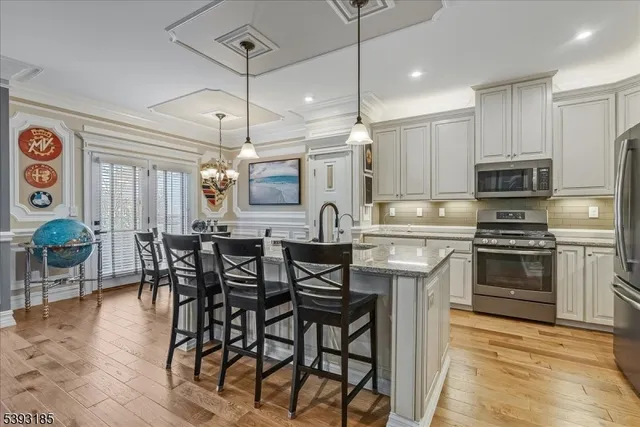 a kitchen with stainless steel appliances kitchen island a table and chairs in it