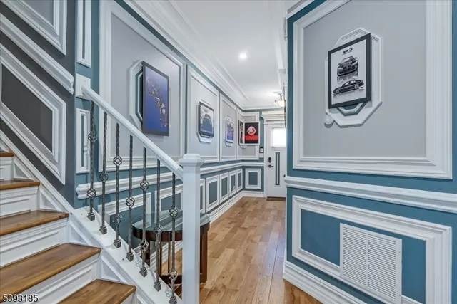 a view of staircase with lots of frames on wall and a window