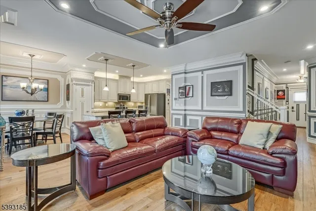 a living room with furniture kitchen view and a chandelier