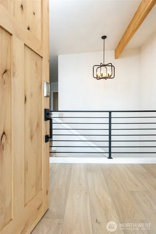 a view of a hallway with wooden floor and staircase
