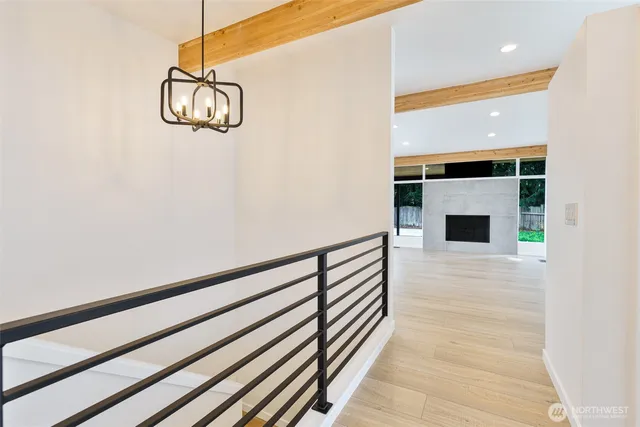 an empty room with wooden floor kitchen refrigerator and window